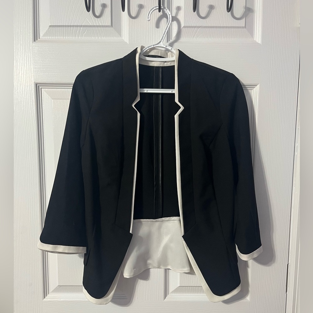 Women’s 3/4 sleeve Black suite jacket with white trim.